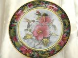 une photo d'une assiette décorée d'un oiseau et de fleurs