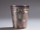 une coupe en argent ancienne posée sur une table blanche