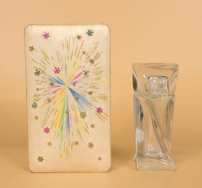 un petit vase en verre posé à côté d'une petite boîte ornée d'un motif en forme d'étoile