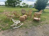 several wicker chairs and a rocking chair in a grassy area