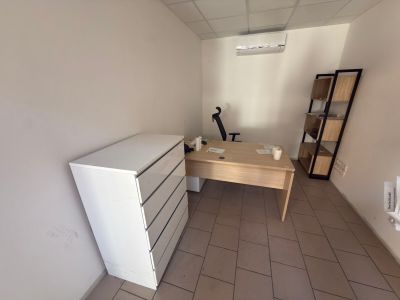 a white refrigerator sitting in the corner of a room next to a desk
