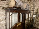 a bed and a chair in a room with a stone wall