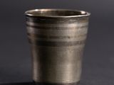 a close up of a metal cup sitting on a table