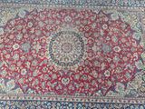 a red and blue rug with a medallion design on it