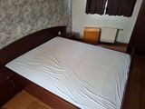a bed with a white sheet on it in a room