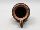an image of a small vase on a white surface