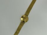 a close up of a gold watch on a white surface