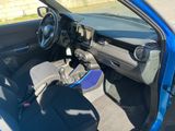 the interior of a small blue car with the door open