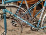 a blue bicycle parked on a wooden floor in a room