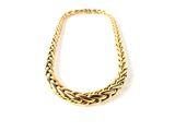gros plan d'un collier en or sur fond blanc