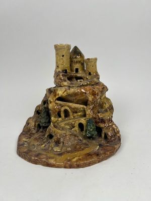 une figurine représentant un château au sommet d'une colline