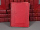 several red books stacked on top of each other on a table