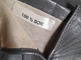 someone is wearing a black leather jacket with a label on it