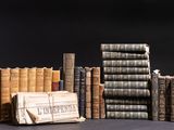 a lot of books that are stacked on top of each other