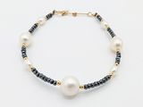 un bracelet composé de perles blanches et de perles noires sur fond blanc