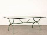 a glass table with metal legs and a glass top