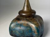 a blue and brown vase sitting on a white surface