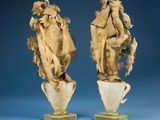 pair of vases with animal heads on each of them on a blue background