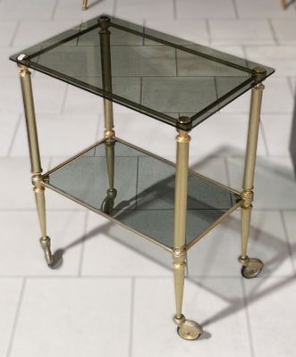 une petite table en verre avec des roulettes, posée à même le sol