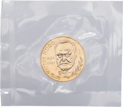 un gros plan d'une pièce de monnaie dans un sachet en plastique posé sur une surface blanche