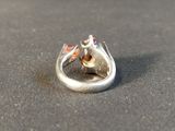 a silver ring with a stone in it on a table