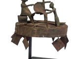statue représentant un homme et une femme travaillant sur un morceau de bois