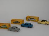 several toy cars are lined up in a row on a white surface