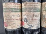 three bottles of red wine sitting next to each other on a table