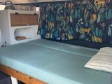a bed in the back of a camper with a blue cover