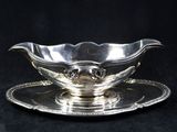 a silver plate with a saucer on it on a black background