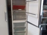 un réfrigérateur blanc dont la porte est ouverte, dans un garage
