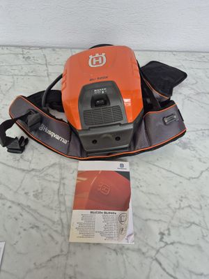 un gros plan d'un aspirateur orange et noir posé sur un sol en marbre