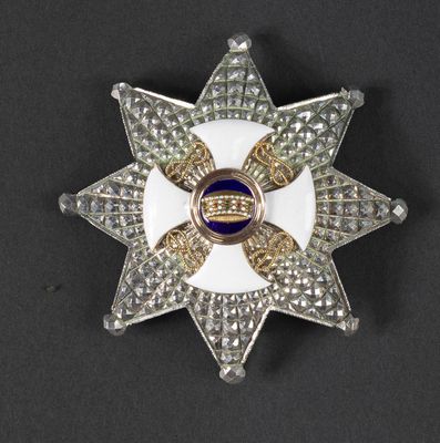 an image of a white and gold star broochle with blue and white stones