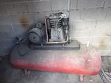 a small air compressor sitting on top of a red tank