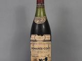 an old bottle of wine sitting on top of a glass table