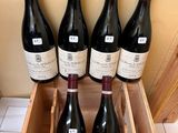 six bottles of wine in a wooden box on a tiled floor