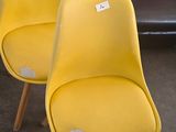 deux fauteuils jaunes placés l'un à côté de l'autre dans un salon