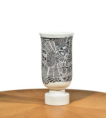 a black and white vase sitting on a wooden table