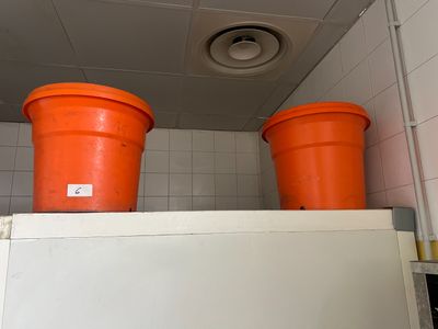 deux seaux orange posés sur un réfrigérateur