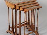 three nesting tables with marble tops on stands on a white background