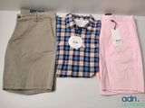 three men ' s shirts and shorts are lined up on a table