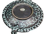 a black plate with blue and white designs on it