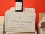 bottles of wine sitting on top of boxes in front of a red wall