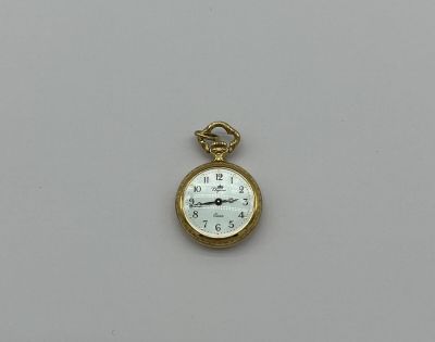 une image représentant une montre de poche posée sur une surface blanche