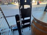 un tonneau en bois posé par terre à côté d'une chaise en métal