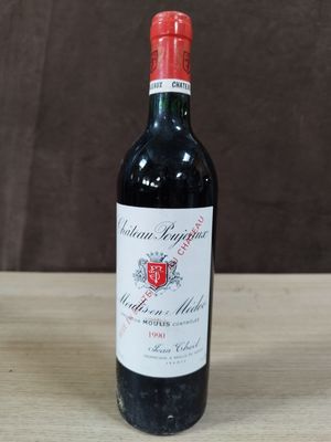 la bouteille de vin rouge est posée sur une table en bois