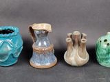 quatre vases de couleurs différentes sont alignés sur une surface noire
