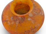 an orange vase that is sitting on a white surface