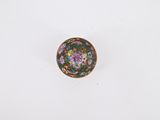 a small bowl on a white surface with a flower design on it