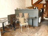 tables and chairs in a room with wood floors and a staircase